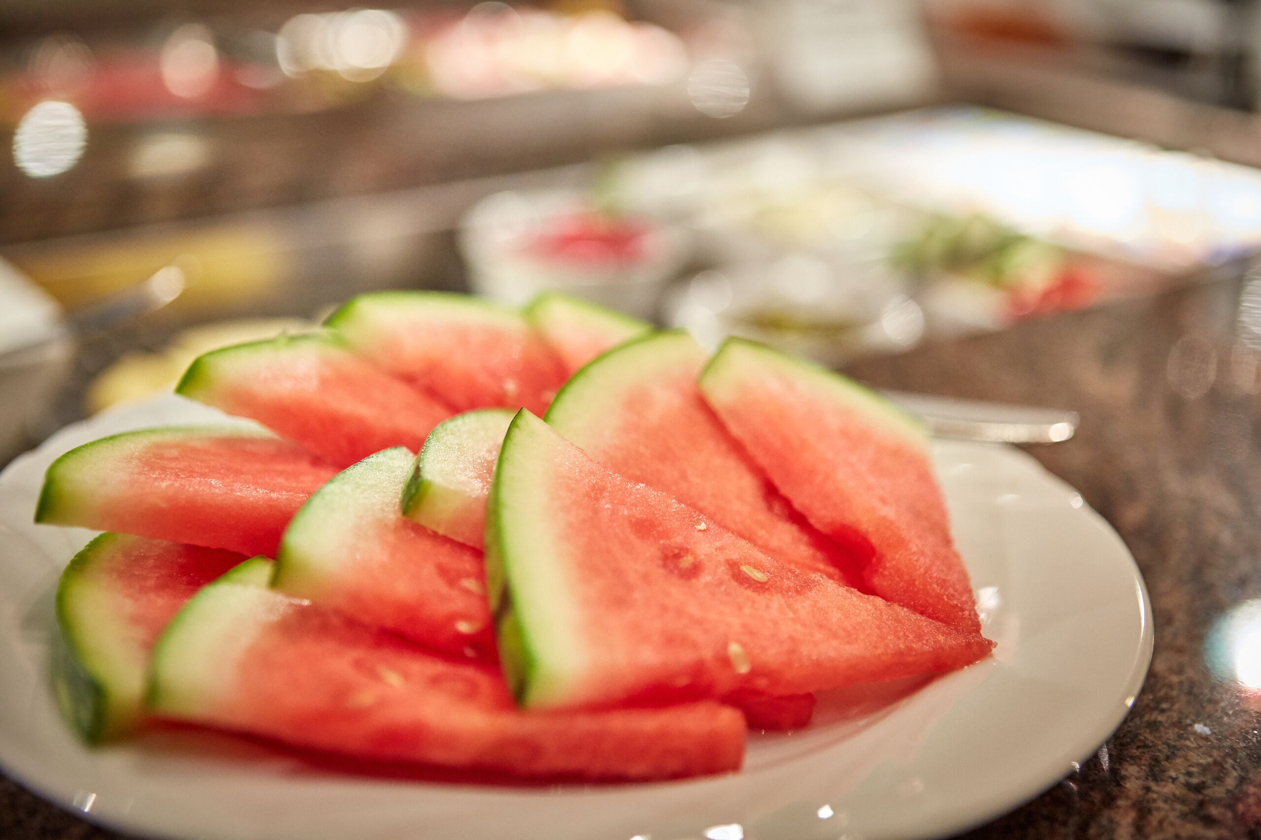 Une assiette de tranches de pastèque sur une assiette blanche.