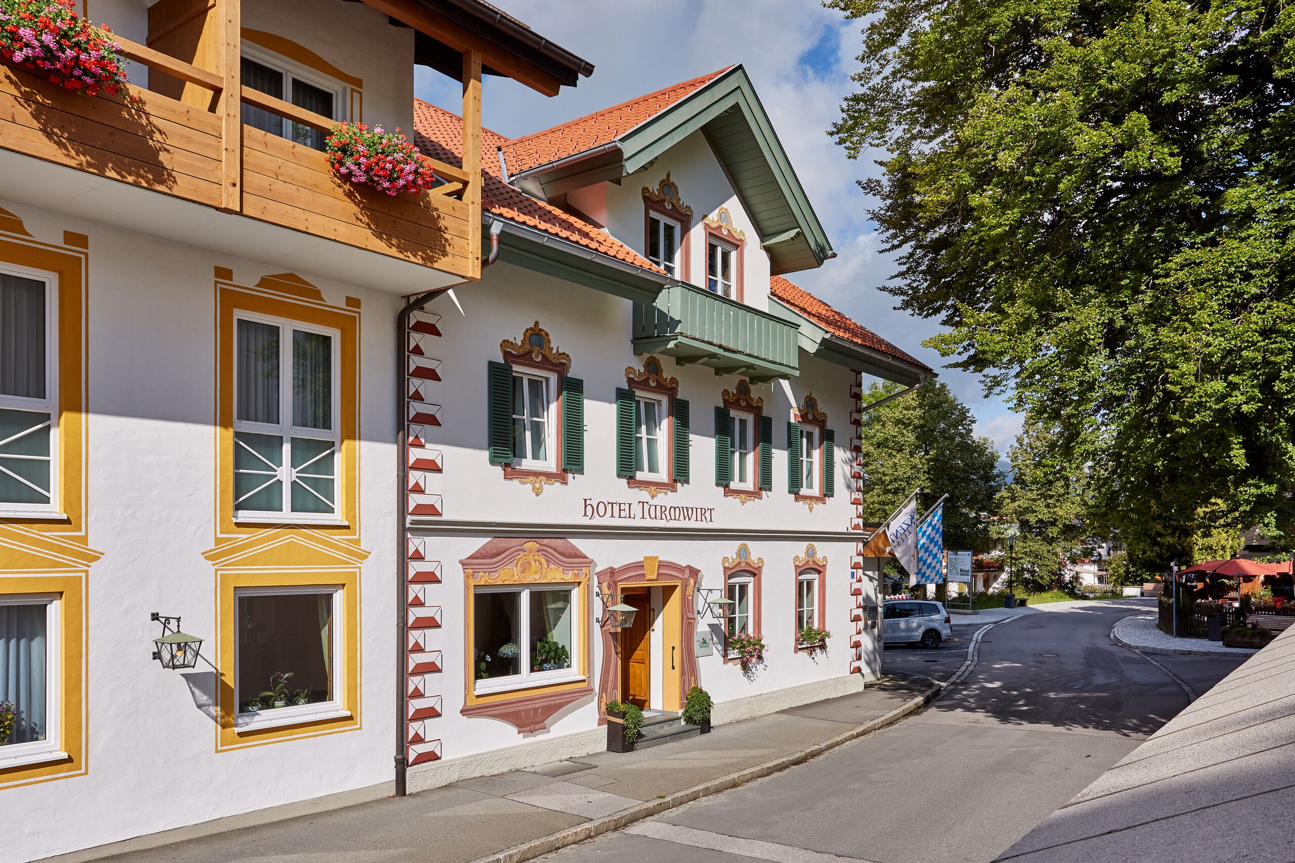 Een traditioneel Europees hotel met een klassiek gevelontwerp, een opvallende ingang en een bord met de naam.