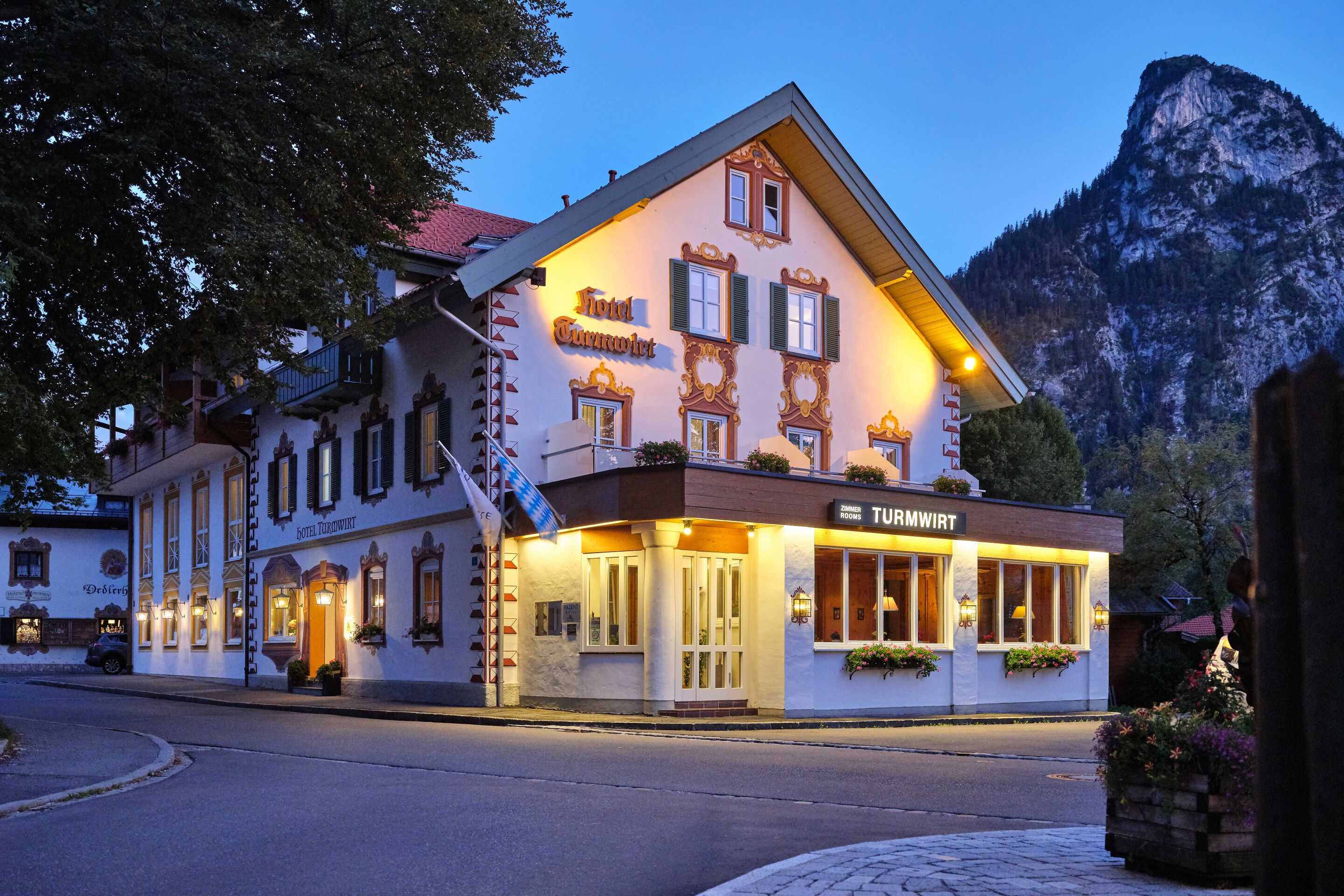 Un hôtel européen traditionnel, avec une façade classique, de nombreuses fenêtres et une enseigne indiquant qu’il s’agit d’un restaurant.