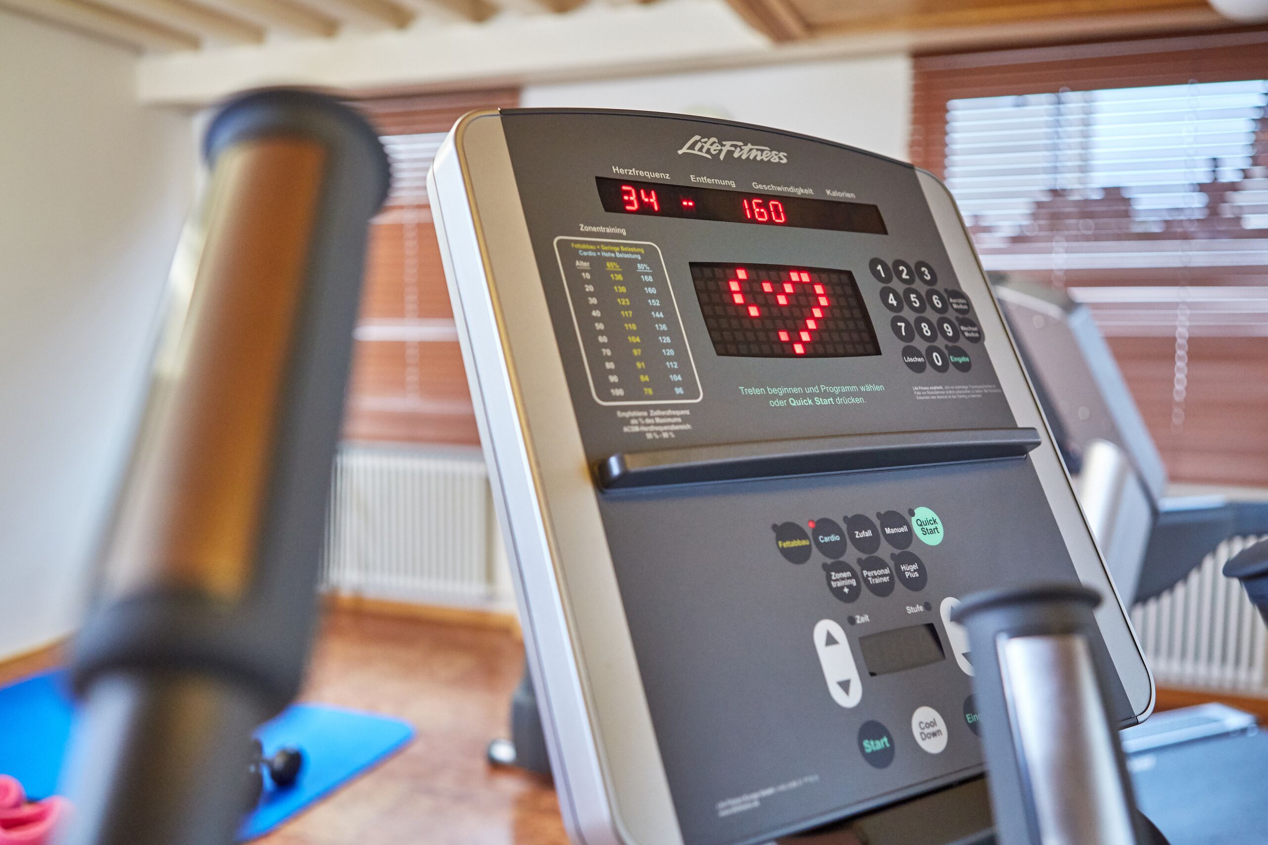 A treadmill with a digital display showing heart rate and other metrics.