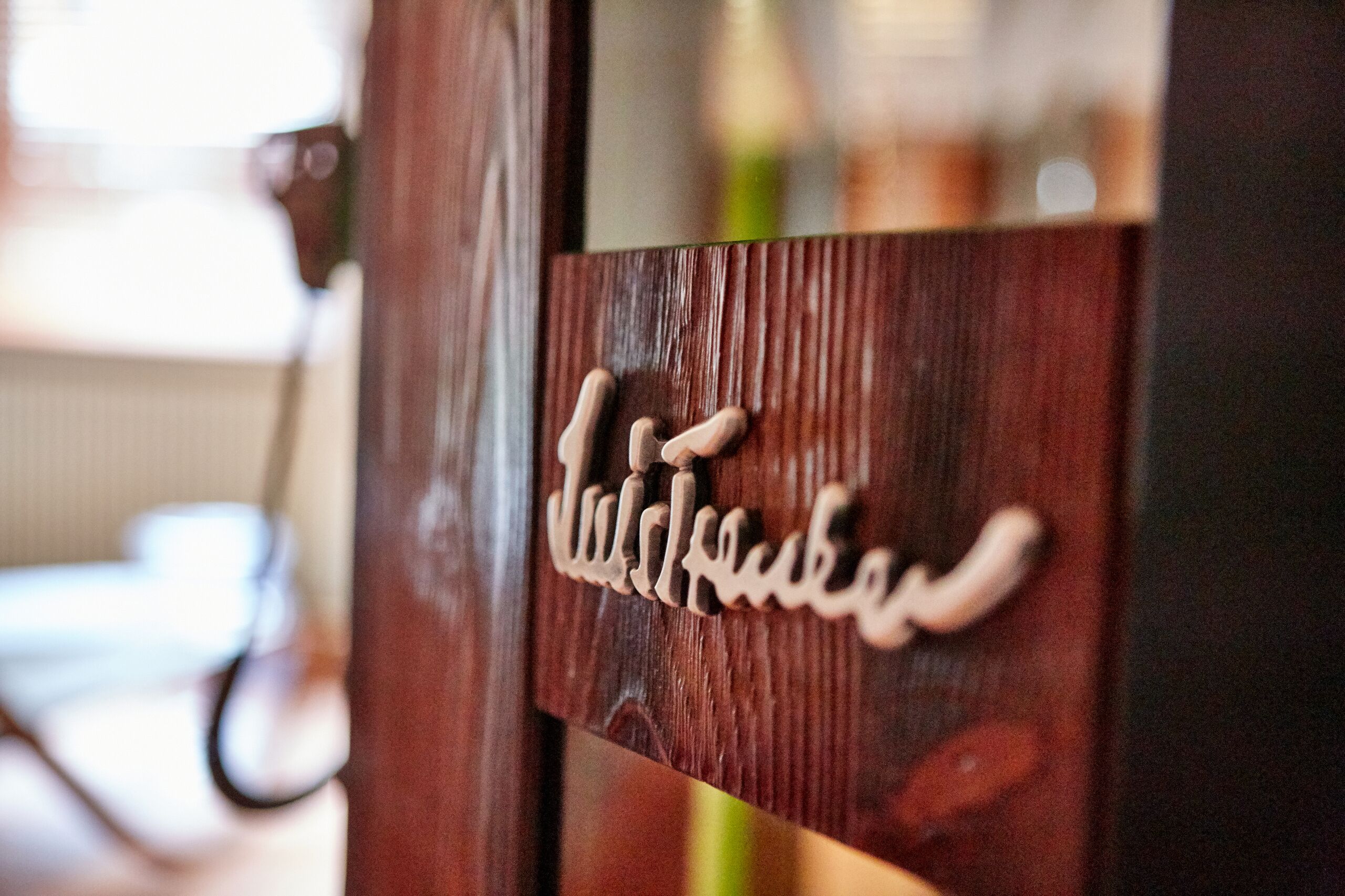 A wooden door with a carved nameplate.