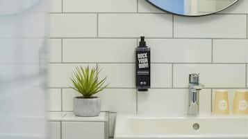 Een bad/douchecombinatie,  milieuvriendelijk toiletgerief, handdoeken