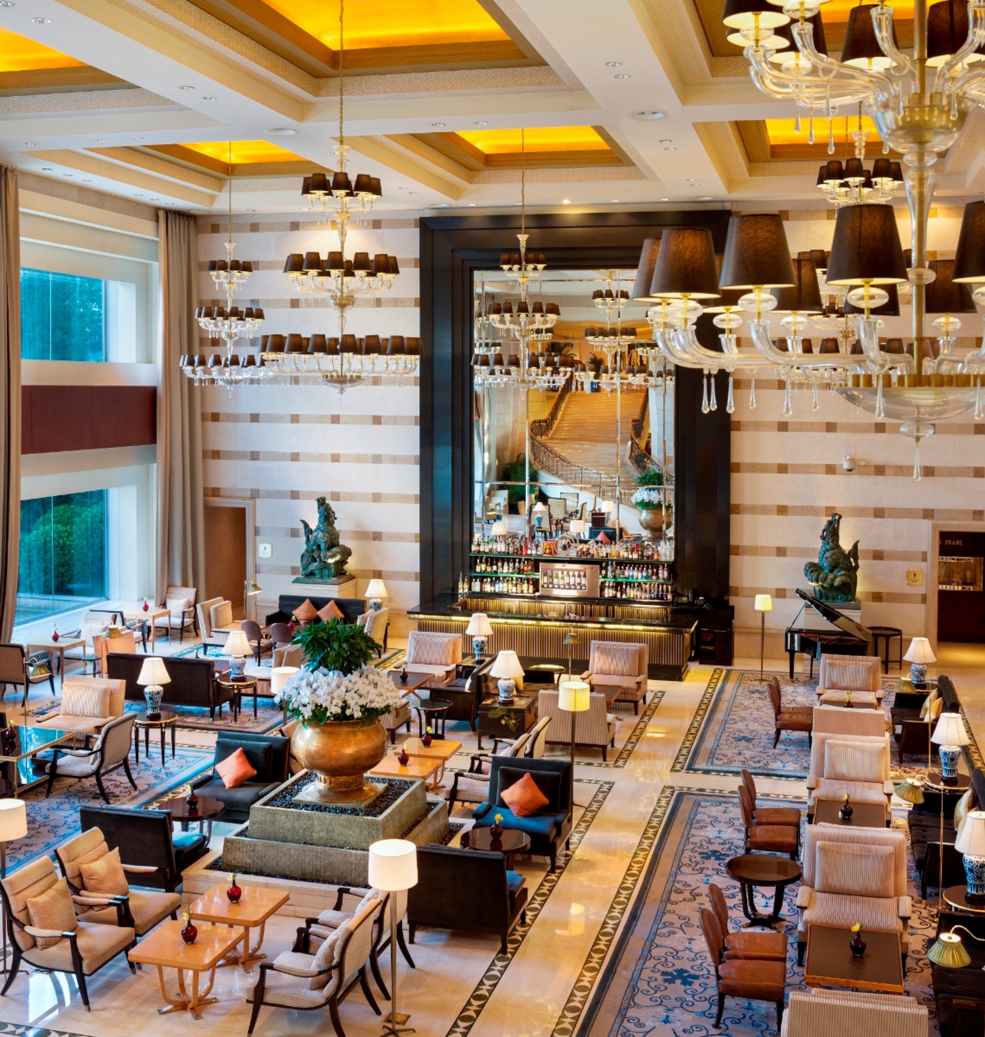 Eine geräumige Lobby mit mehreren Sitzbereichen, einer Bar und einem Klavier.