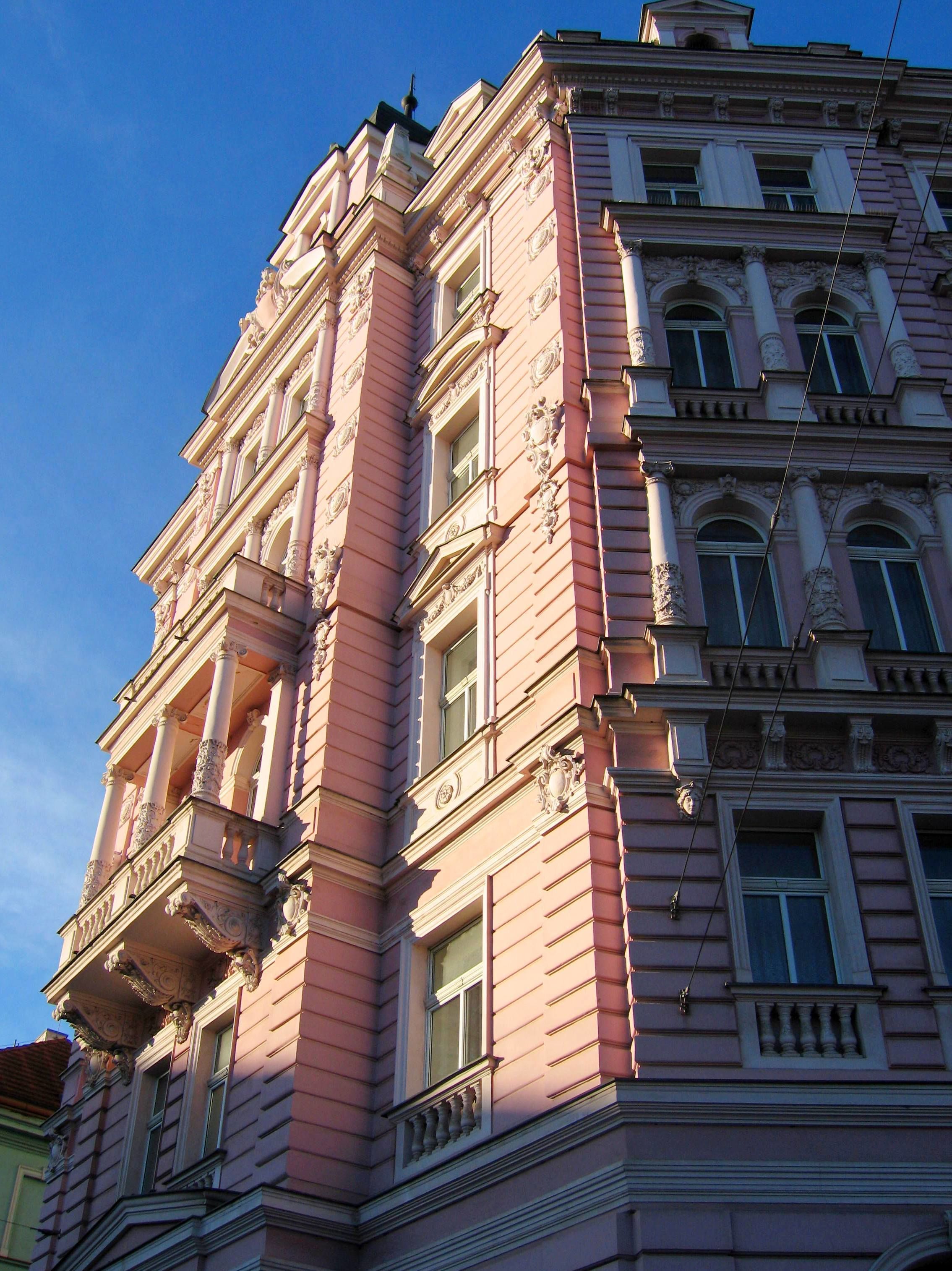 Un edificio de varios pisos con detalles arquitectónicos clásicos, incluyendo columnas y balcones decorados.