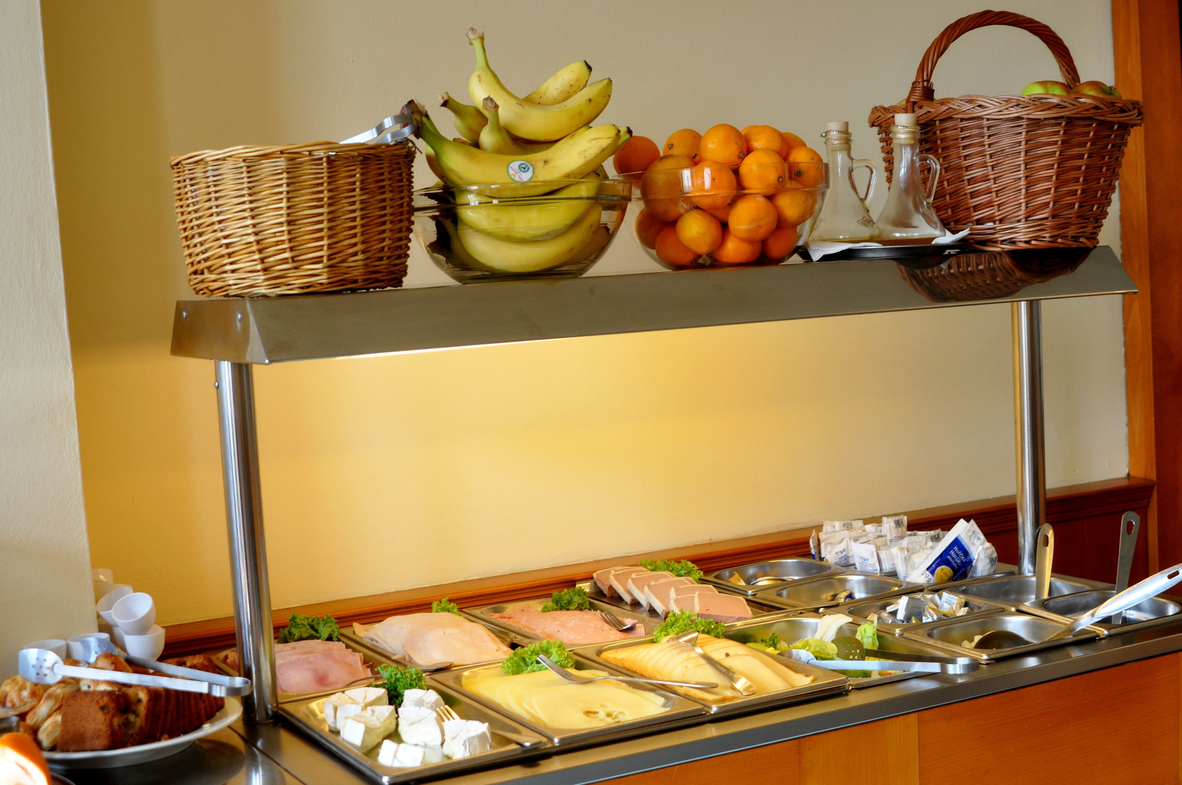 A buffet with various food items and utensils.
