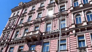 Un edificio rosa con letreros que dicen "HOTEL" y "ÓPERA".