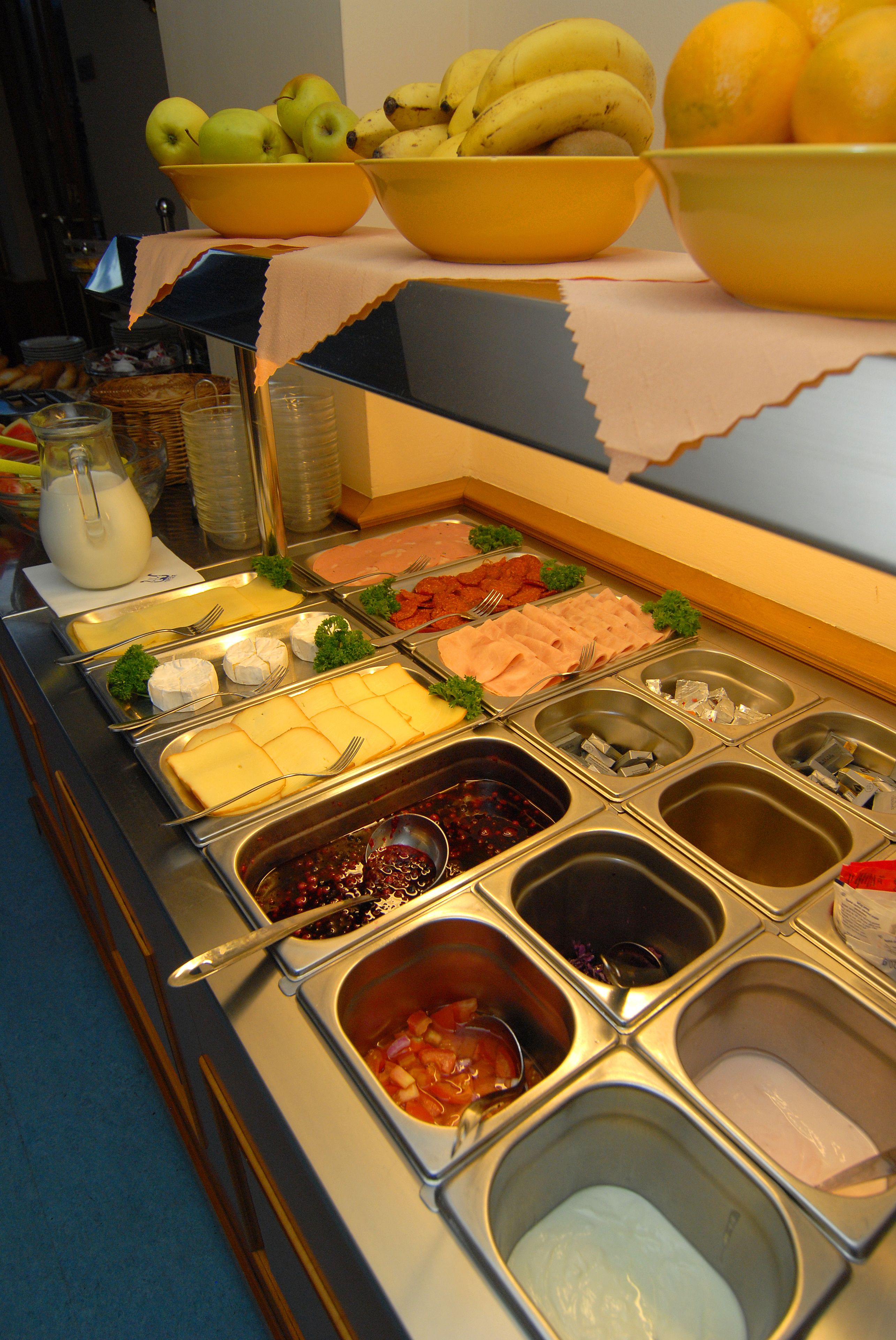 A buffet with various food items and utensils.