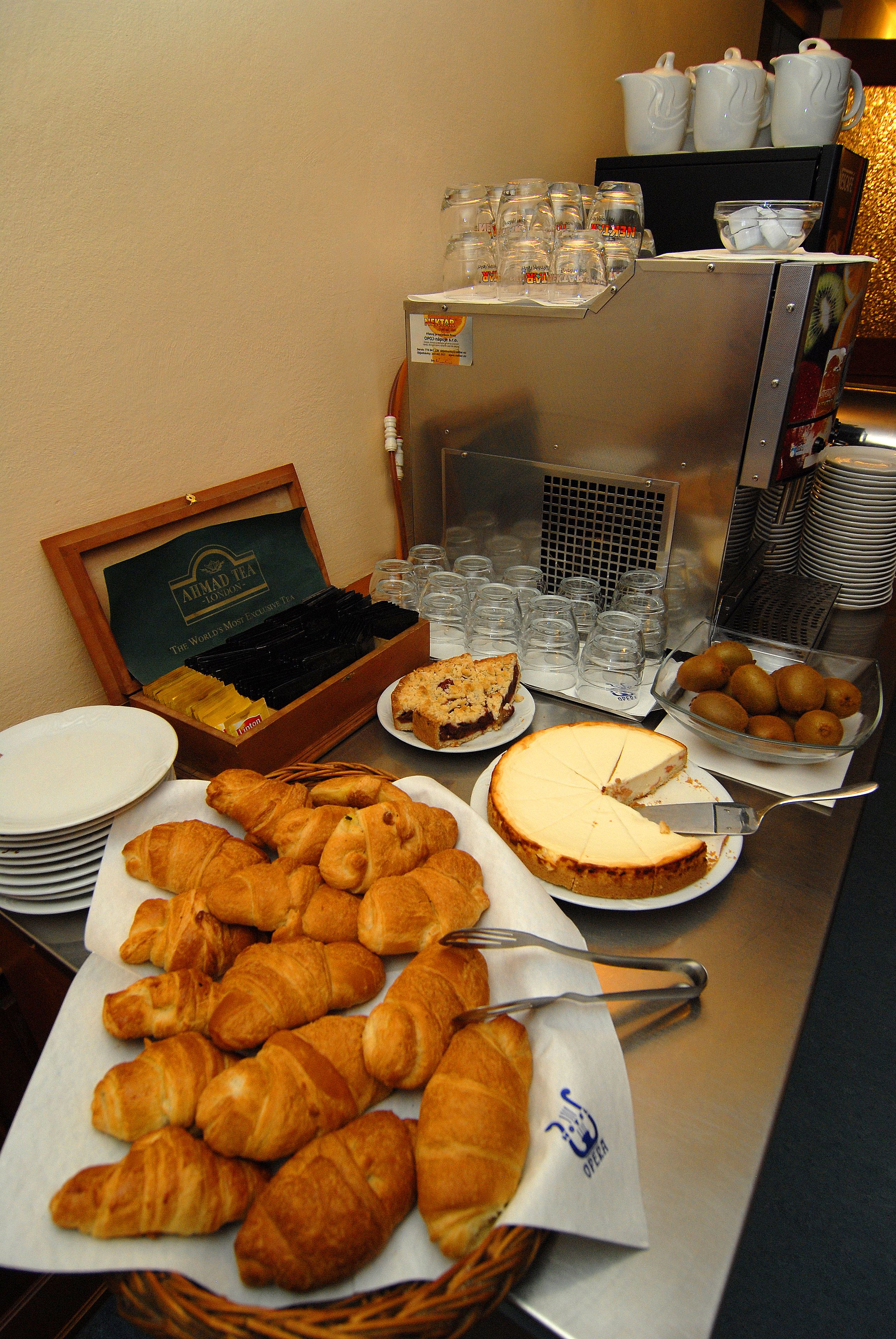Buffet variat amb diversos aliments, incloent pastissos, un pastís de formatge i un bol de peres.