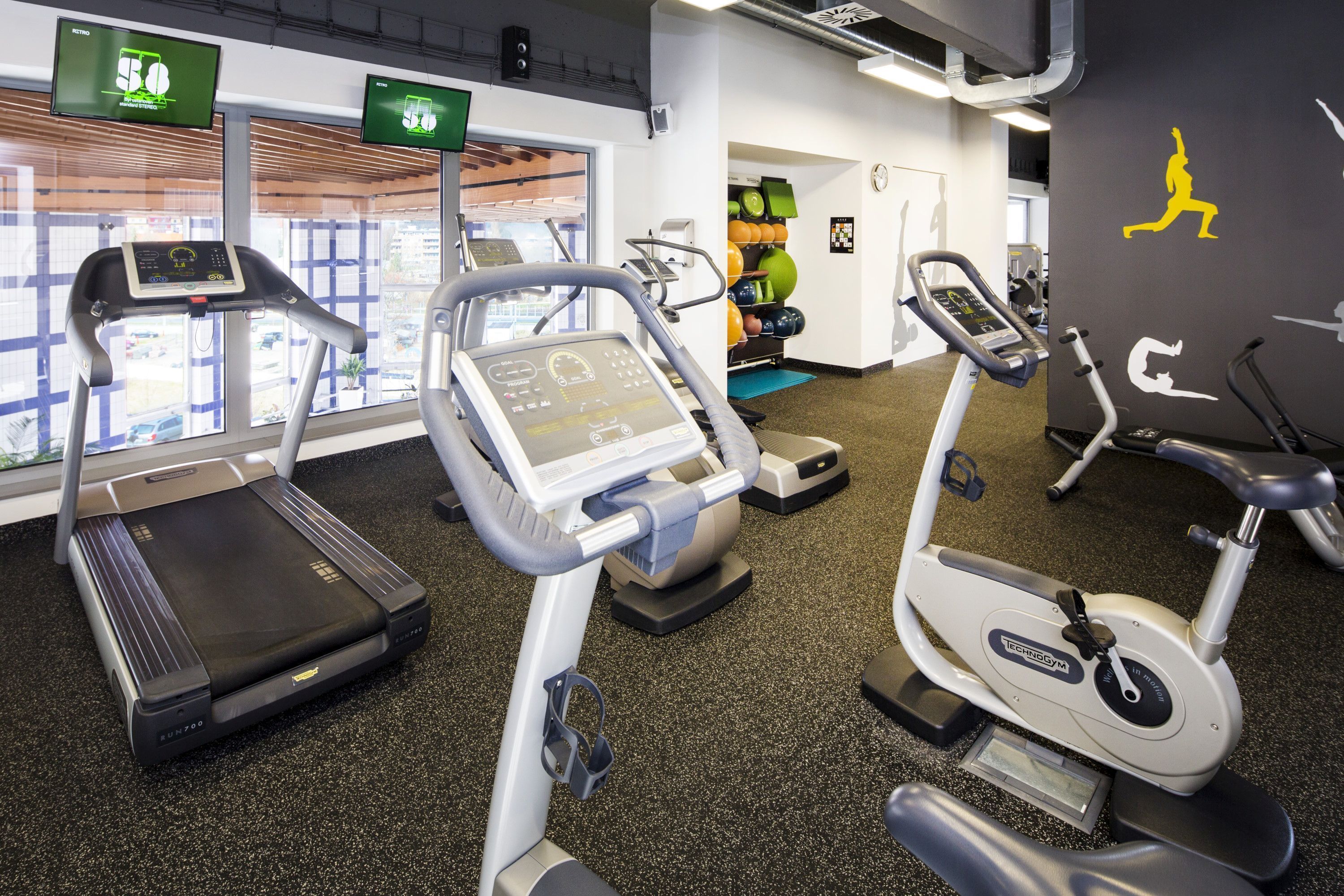 A gym with treadmills, stationary bikes, and exercise equipment.
