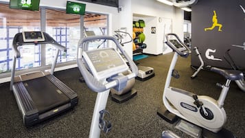 A gym with treadmills, stationary bikes, and exercise equipment.