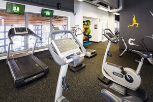 Una palestra con tapis roulant, cyclette e attrezzature per esercizi.