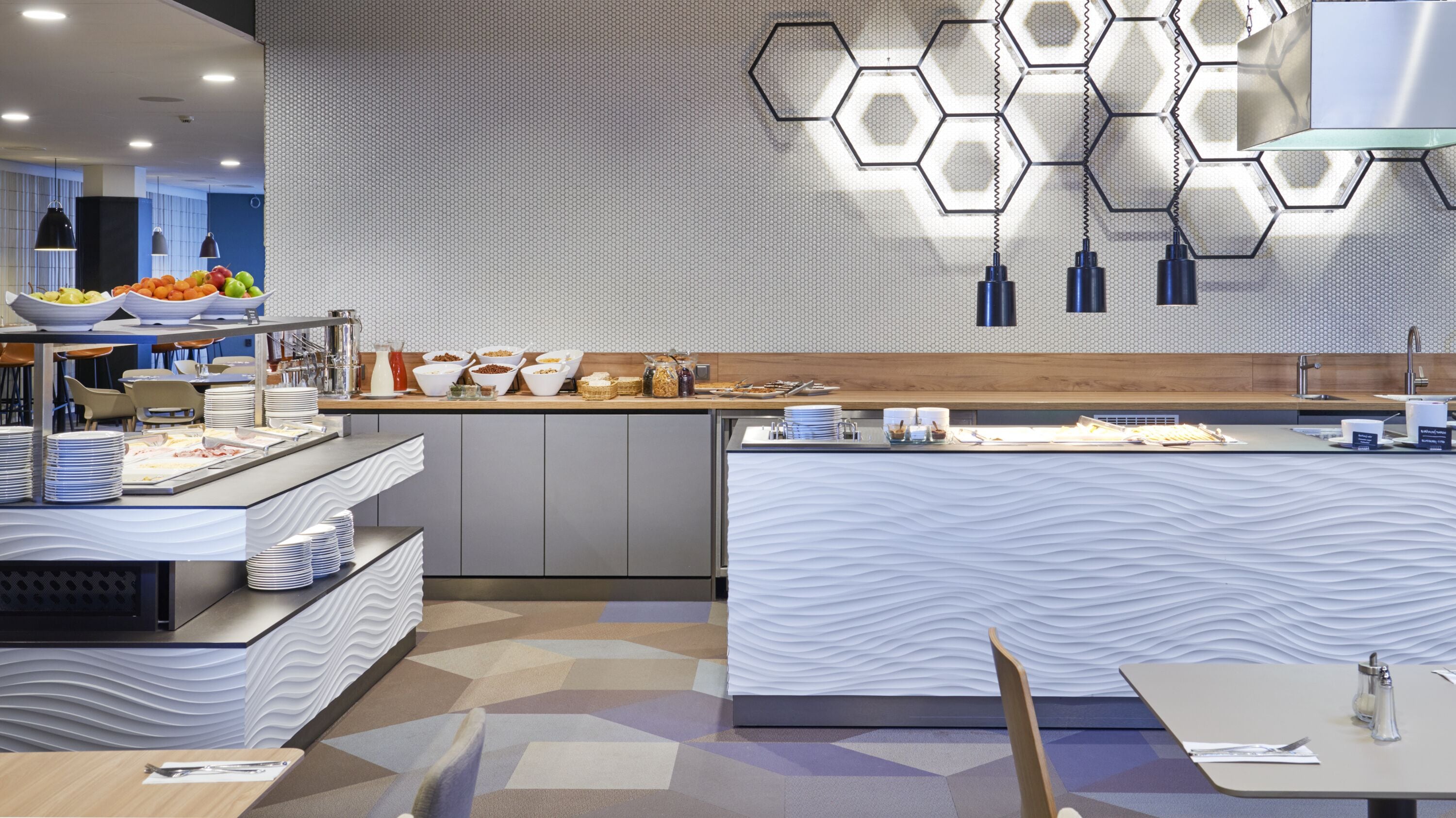 Un ricco buffet della colazione in stile moderno, con diverse opzioni tra cui scegliere e un'originale lampada a forma esagonale.