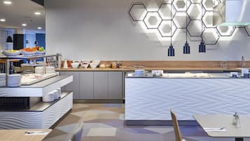 A modern breakfast buffet with a variety of food items and a unique hexagonal light fixture.