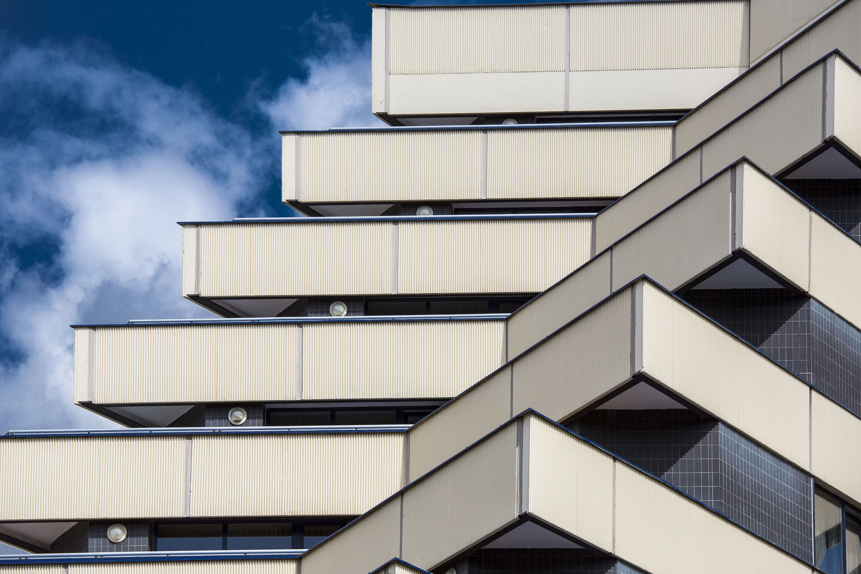 Un bâtiment moderne doté de nombreux balcons et de grandes fenêtres.