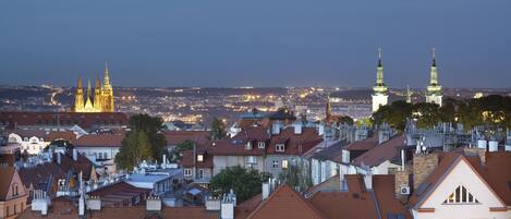 A cityscape with a prominent cathedral and a church with spires, surrounded by residential buildings with red-tiled roofs.