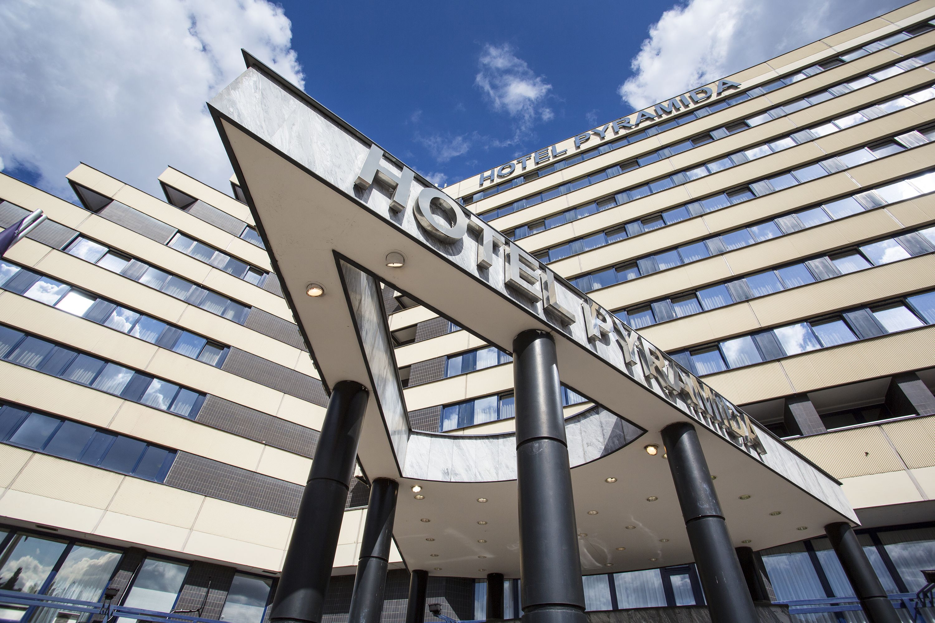 A modern hotel building with a prominent sign reading "HOTEL PYRAMIDA."