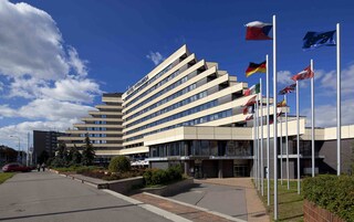 Een modern hotel met een uniek hoekig ontwerp, meerdere vlaggen en een goed onderhouden buitenruimte.