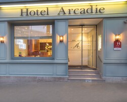 Hotel Arcadie, con un área de recepción visible a través de las puertas de vidrio.