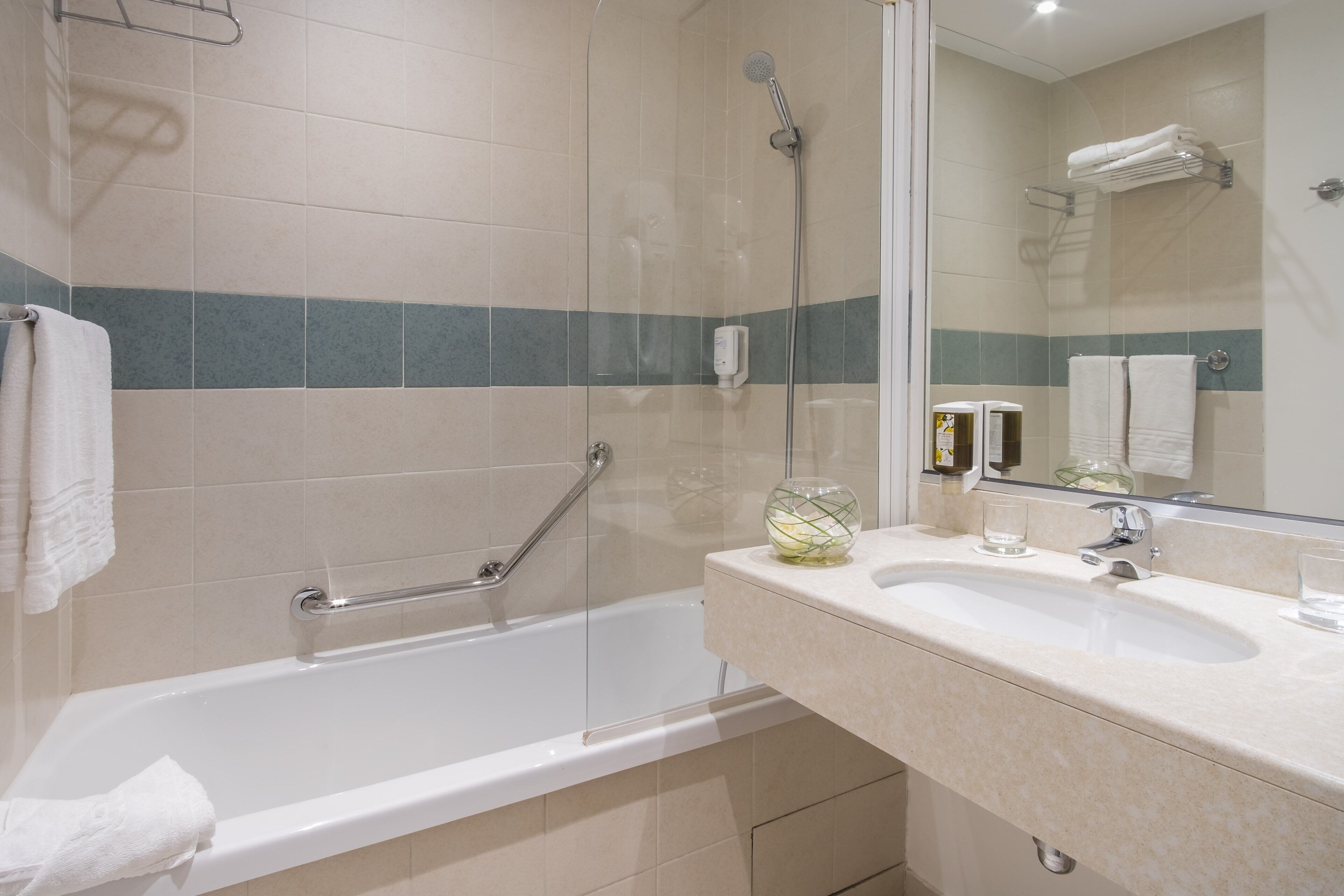 Un baño con bañera, lavamanos y cabina de ducha de vidrio.