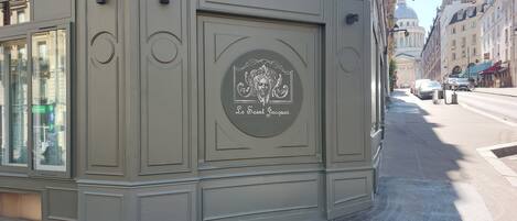 A building facade with a circular emblem featuring a profile of a person and the text "Le Saint Jacques."
