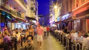 A bustling street lined with outdoor seating at various restaurants, with people dining and walking along the path. - Hotel Festival (Cannes)