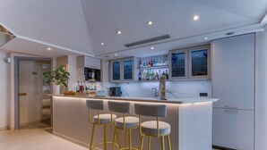 Una cucina moderna con zona bar, sgabelli da bar e una pianta in vaso.