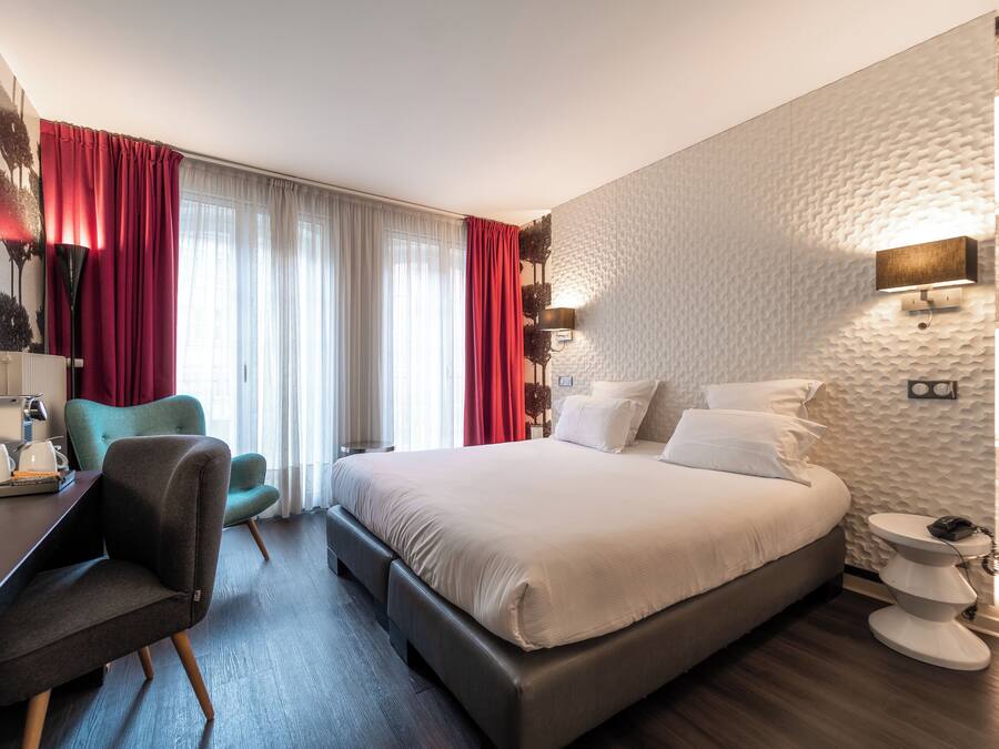 Una habitación de hotel moderna con una cama grande, un escritorio y una silla.