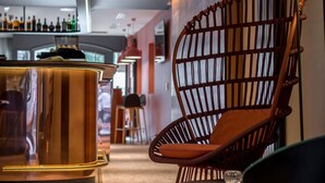 Una zona de bar moderna con una olla de cobre, sillas de madera y una barra.