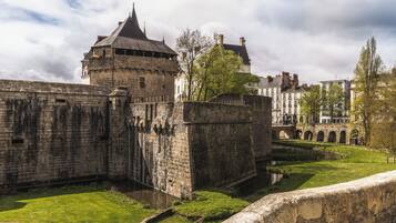 A historic stone fortress with a moat and a bridge.