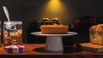 A cake on a white cake stand with a dark background.