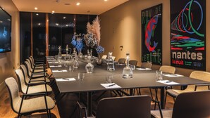 A conference room with a long table, chairs, and decorative vases. - L'Hôtel - Face au Château - Boutique Hôtel et Séminaires (Nantes)