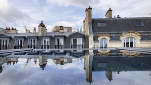 A row of traditional European-style buildings with a reflective pool in front. - Le 46 Hotel (Paris)