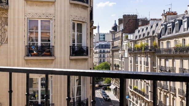 A row of historic buildings with ornate balconies and a clear view of the street below. - Le 46 Hotel (Paris)