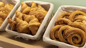 Two baskets of pastries on a wooden shelf.