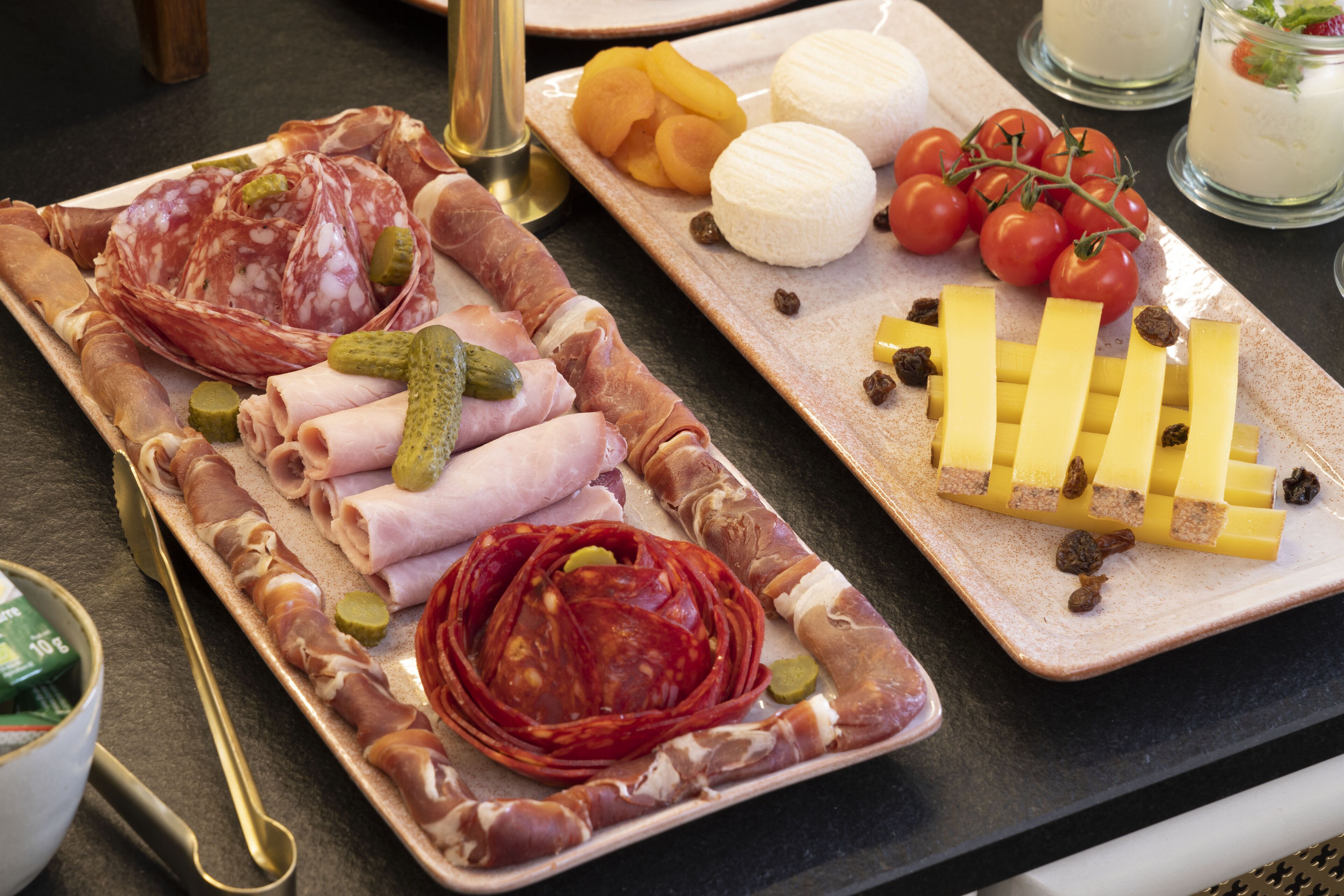 A charcuterie board with various meats, cheeses, and pickles.