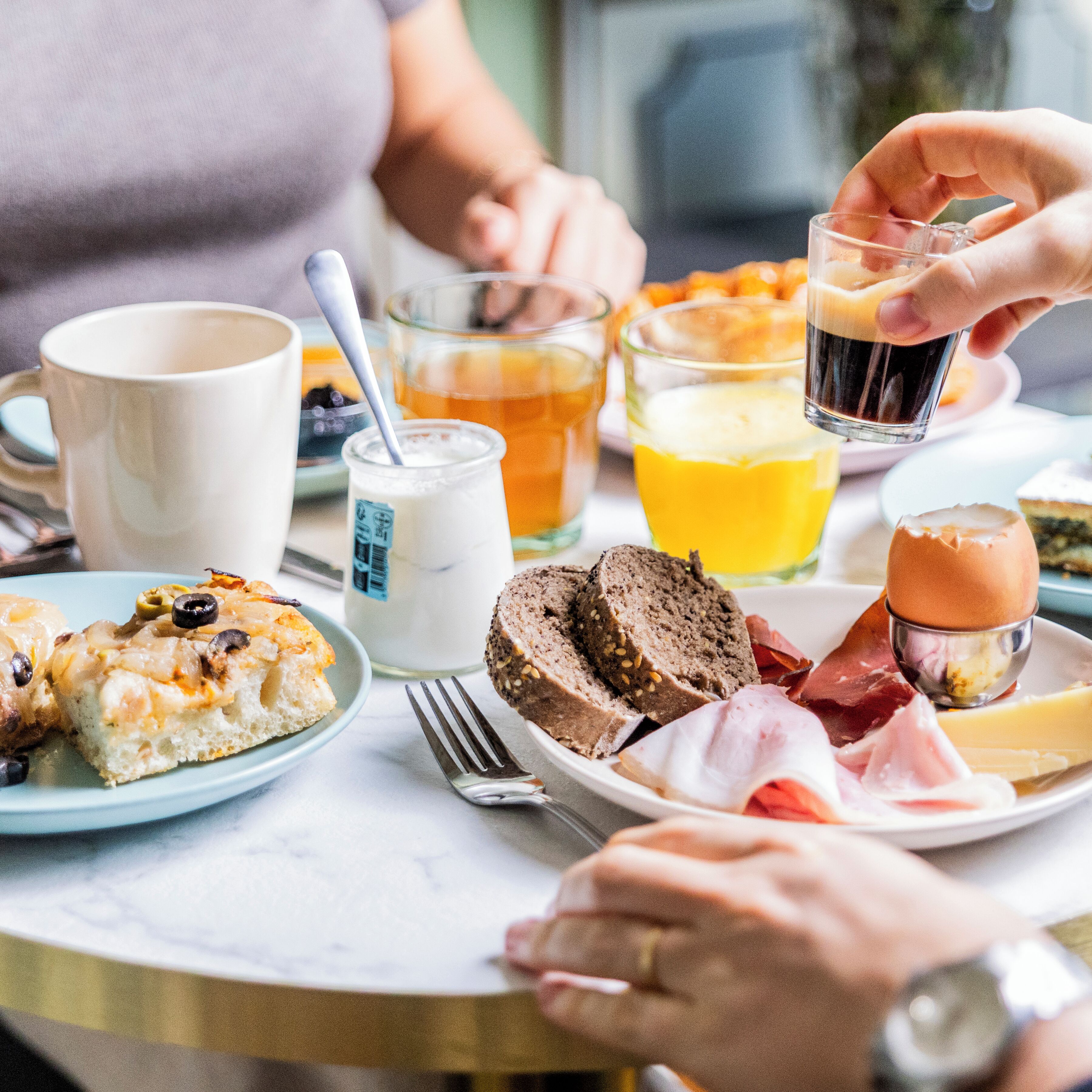 A breakfast setting with various food items and drinks on a table.