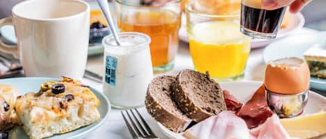 A breakfast setting with various food items and drinks on a table.