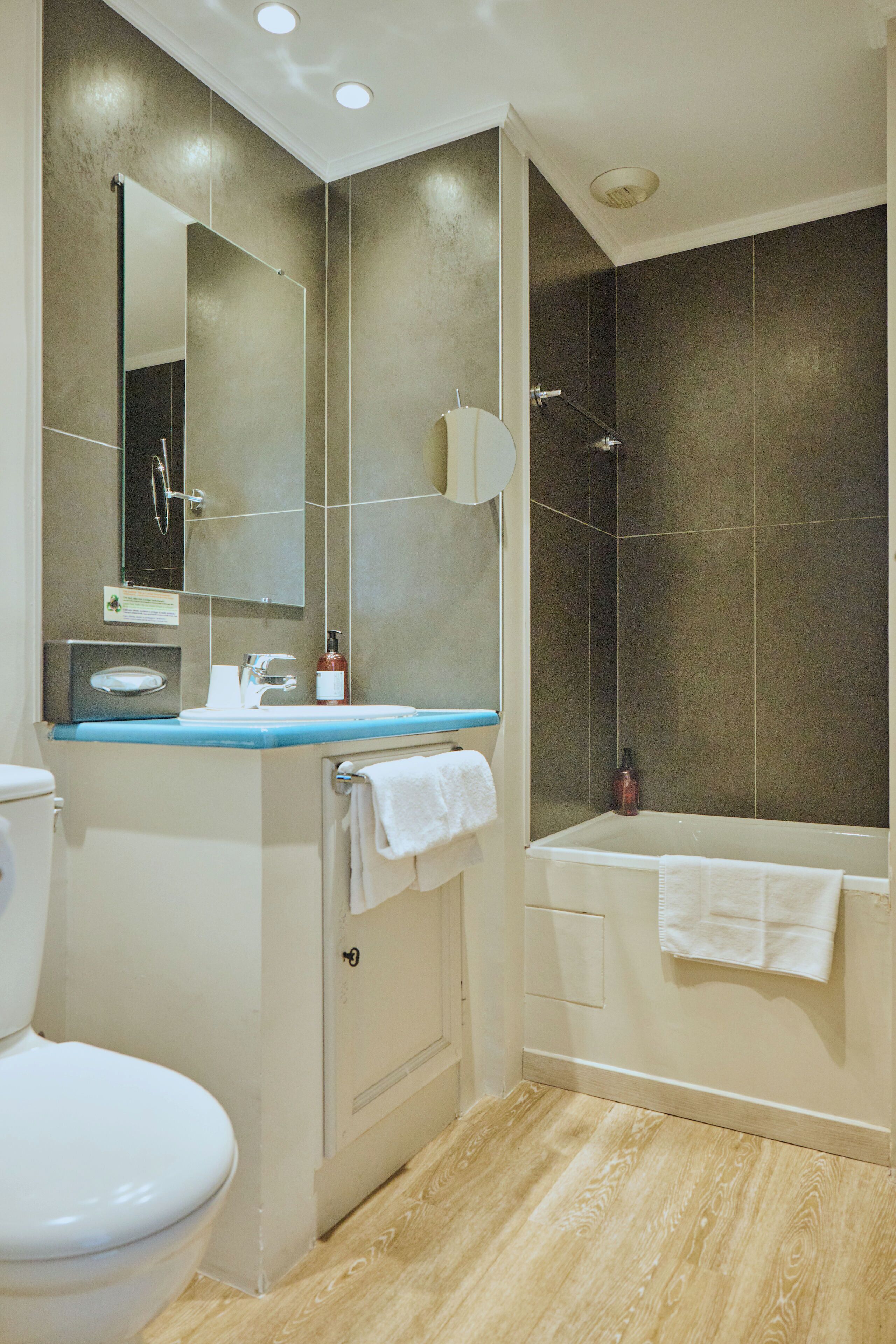 Une salle de bain moderne équipée de toilettes, d’un lavabo, d’un miroir et d’un espace douche.