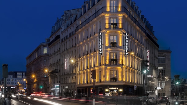 A historic hotel with classic architecture, multiple stories, and illuminated signage. - Hotel Albert 1er Paris Lafayette (Paris)