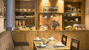 A well-lit breakfast bar with wicker baskets, a coffee machine, and a variety of breakfast items. - Hotel Albert 1er Paris Lafayette (Paris)
