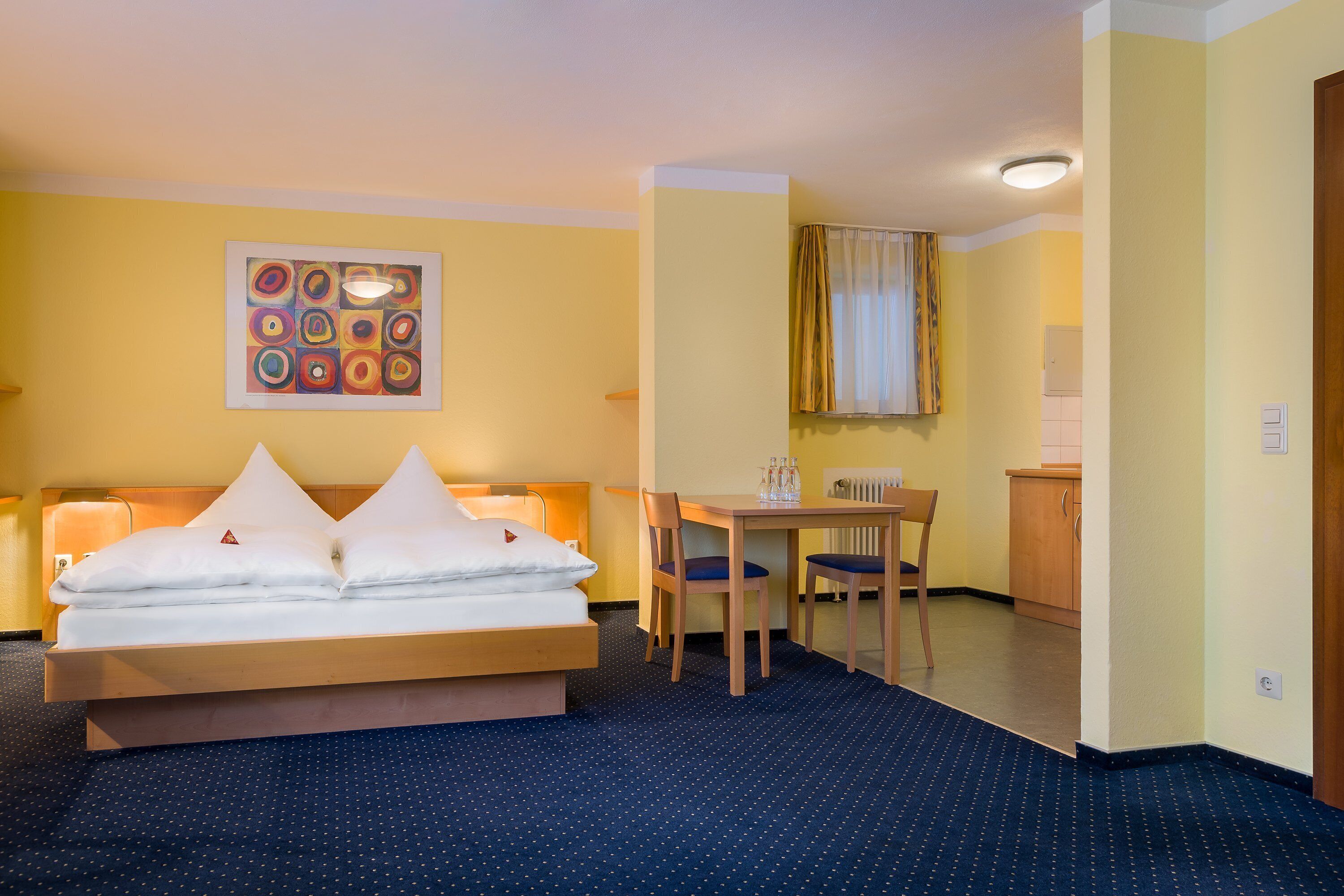 A hotel room with a bed, a desk, and a chair.