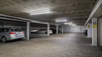 Un parking à étages, avec des piliers en béton et un sol carrelé.