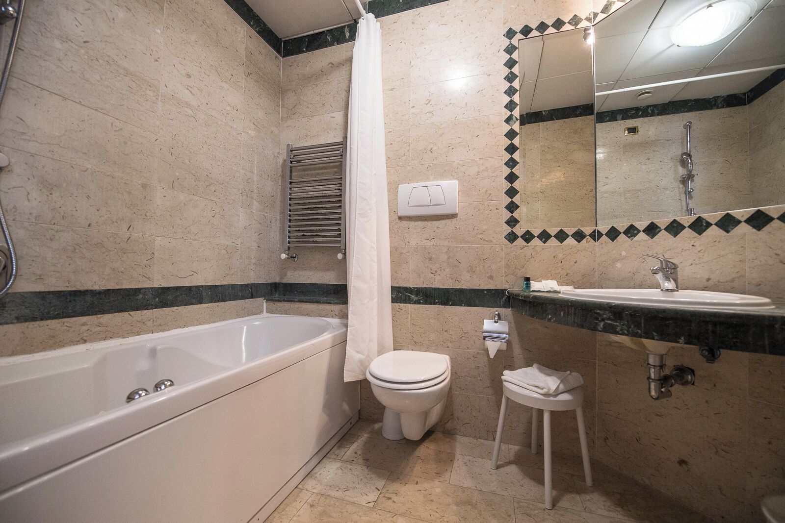 A bathroom with a bathtub, toilet, sink, and a mirror.