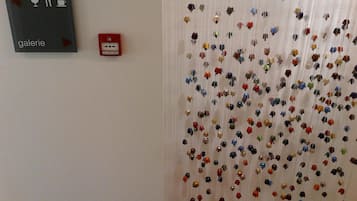 Een muur met een bordje met de tekst 'galerie' en een rookmelder.