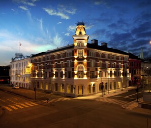 A historic building with a central tower, multiple windows, and a corner location.