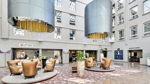 A spacious lobby with a reception desk, seating area, and a sign for breakfast & banquet.