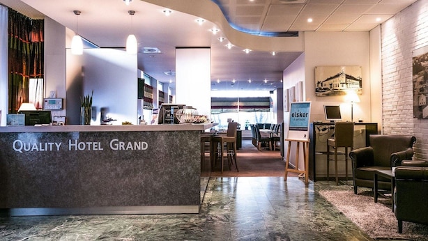 A hotel lobby with a reception desk, seating area, and a view of the dining space. - Quality Hotel Grand Steinkjer (Steinkjer)