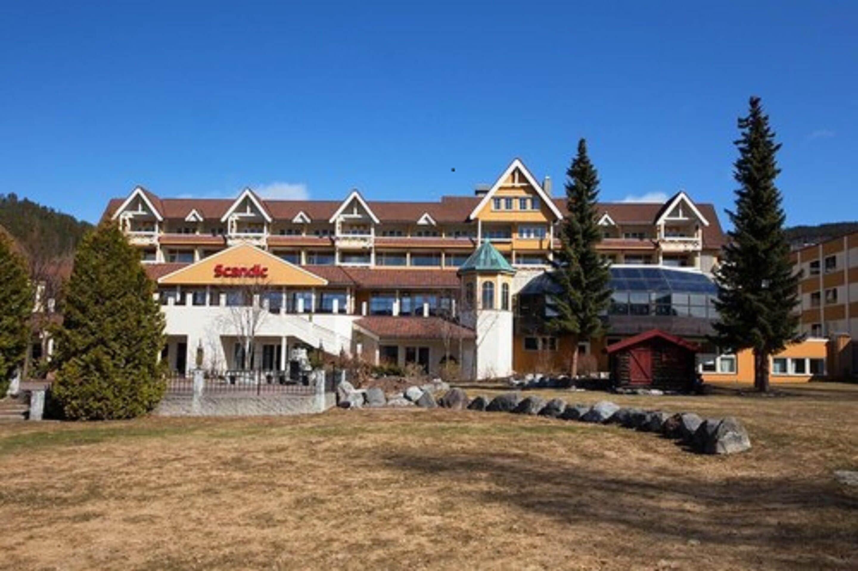 A Scandic hotel with a traditional architectural style, featuring multiple balconies and a central entrance.