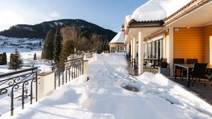 A snow-covered outdoor area with a building featuring a balcony and outdoor seating. - Scandic Valdres (Nord-Aurdal)