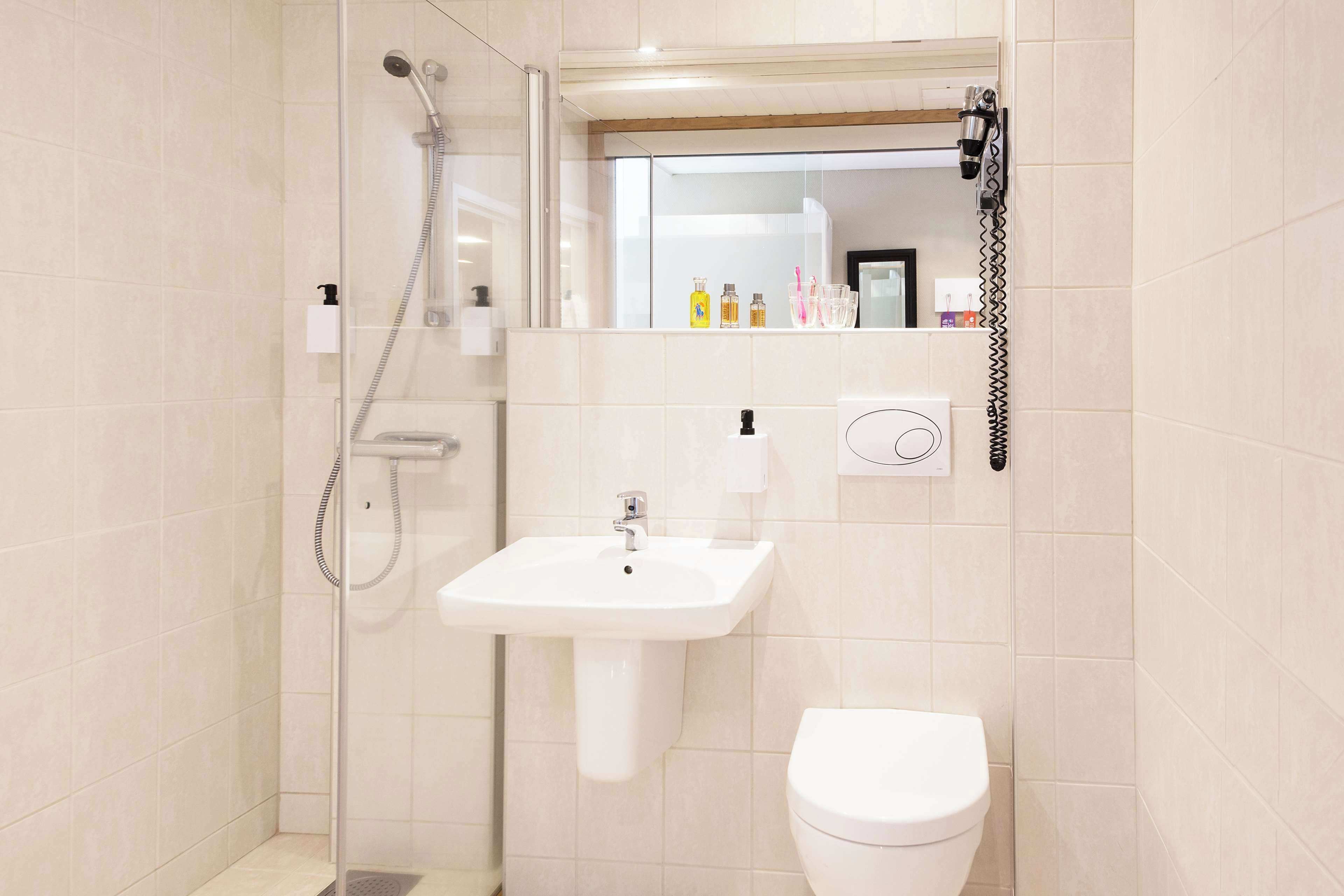 Une salle de bain moderne équipée d’une douche, d’un lavabo et de toilettes.